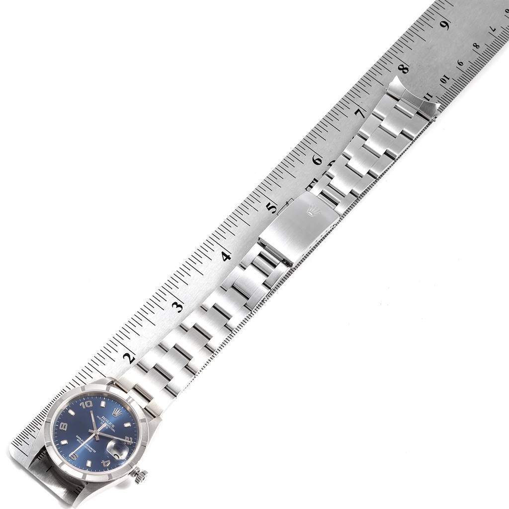 The image shows a Rolex Date 15210 Men's Stainless Steel Blue Dial 15210 Men's Stainless Steel Blue Dial model watch laid alongside a ruler measuring its stainless steel bracelet.