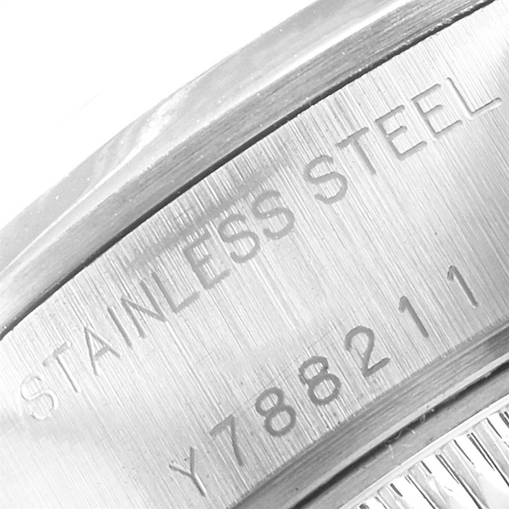 This image shows a close-up of the case back edge of a Rolex Date 79160 Women
s Stainless Steel White Dial 79160 Women
s Stainless Steel White Dial model watch with the "STAINLESS STEEL" engraving and serial number.