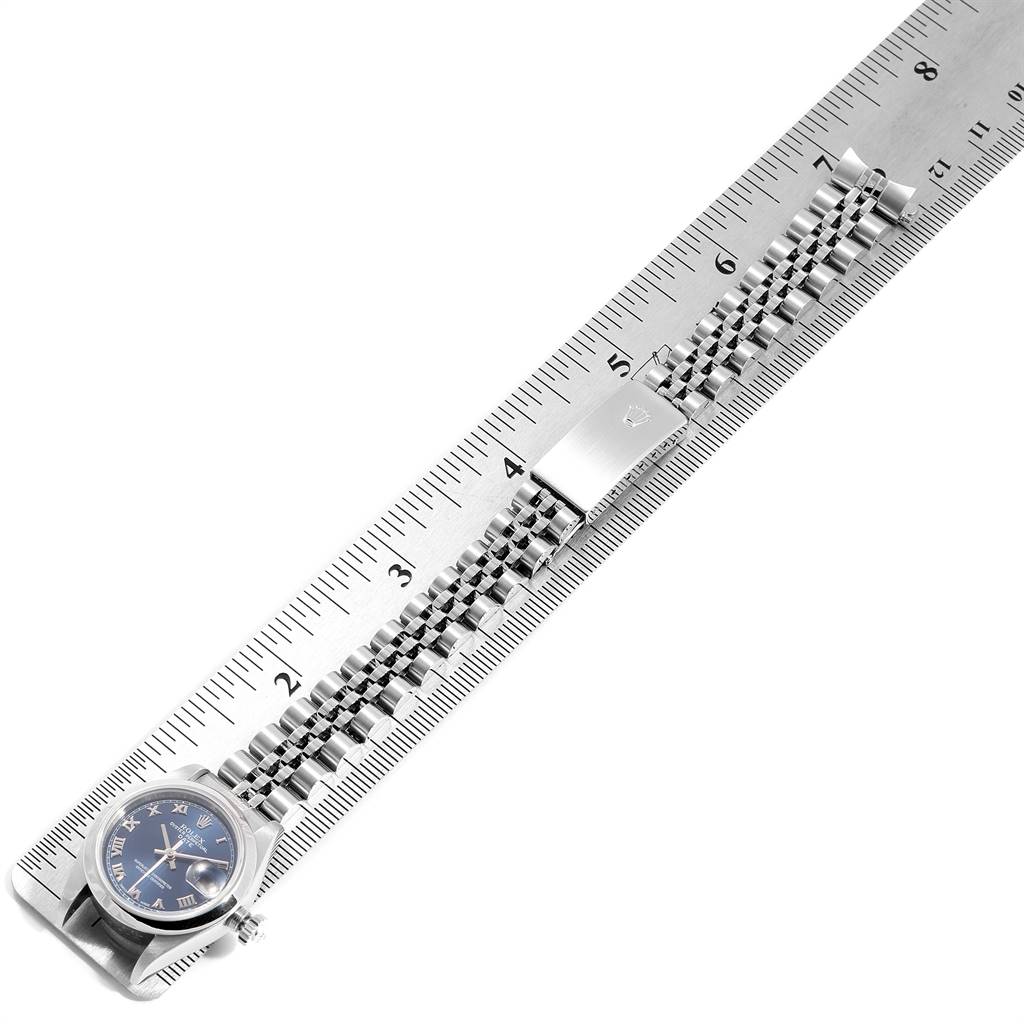 The Rolex Date 79160 Women
s Stainless Steel Blue Dial 79160 Women
s Stainless Steel Blue Dial model watch is shown laid flat on a ruler, displaying its face, crown, and bracelet.