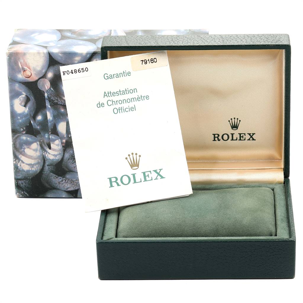 The image shows an open box and warranty card for a Rolex Date 79160 Women
s Stainless Steel Blue Dial 79160 Women
s Stainless Steel Blue Dial model watch, with the interior and cushion visible.