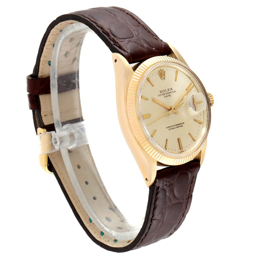 The Rolex Date 1503 Men's Yellow Gold Champagne Dial 1503 Men's Yellow Gold Champagne Dial watch is shown at an oblique angle, highlighting its face, crown, and brown leather strap.
