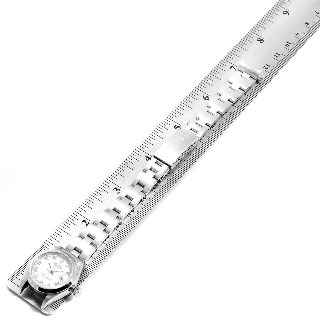 The Rolex Date 79160 Women's Stainless Steel White Dial 79160 Women's Stainless Steel White Dial watch shows the face and bracelet laid against a ruler, highlighting its length.