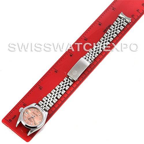 The image shows a Rolex Date 79160 Women's Stainless Steel Pink Dial 79160 Women's Stainless Steel Pink Dial model watch laid flat next to a red ruler, highlighting the watch face and metal bracelet.