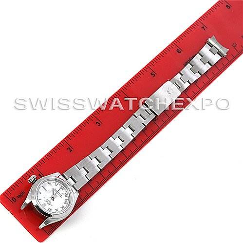 The image shows a Rolex Date 79160 Women
s Stainless Steel White Dial 79160 Women
s Stainless Steel White Dial model watch laid flat next to a red ruler, highlighting the watch face and metal bracelet.