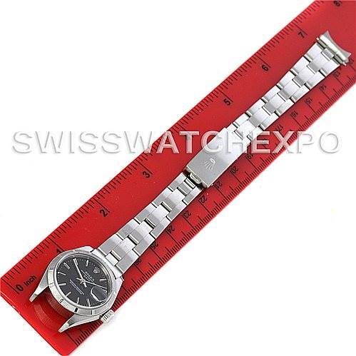 The Rolex Date 79190 Women's Stainless Steel Black Dial 79190 Women's Stainless Steel Black Dial watch is shown laid flat against a red ruler, displaying its face, bracelet, and clasp.