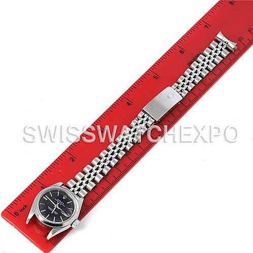 This image shows a Rolex Date 79160 Women's Stainless Steel Black Dial 79160 Women's Stainless Steel Black Dial model watch laid flat beside a red ruler, highlighting its length and bracelet details.