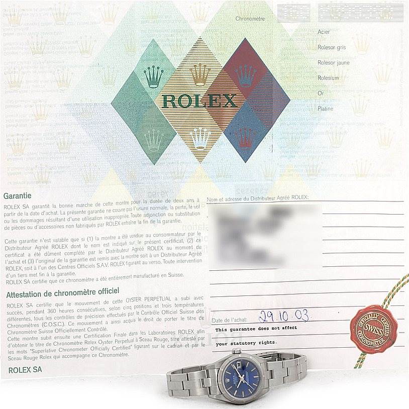 The image shows a Rolex Date 79190 Women's Stainless Steel Blue Dial 79190 Women's Stainless Steel Blue Dial model watch laying flat, along with its warranty document.