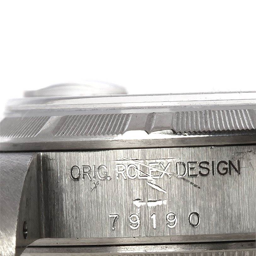 The image shows a close-up of the side of a Rolex Date 79190 Women's Stainless Steel Blue Dial 79190 Women's Stainless Steel Blue Dial model watch, focusing on the engravings.