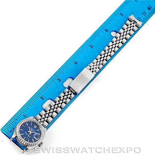 The image shows a Rolex Date 69240 Women's Stainless Steel Blue Dial 69240 Women's Stainless Steel Blue Dial watch horizontally aligned with a blue ruler, displaying the watch face and full jubilee bracelet.