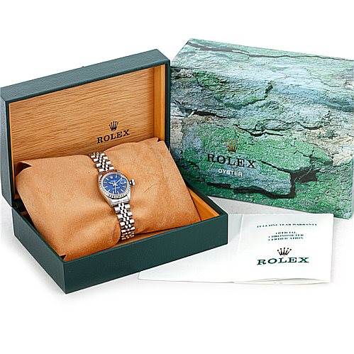 The image shows a Rolex Date 69240 Women's Stainless Steel Blue Dial 69240 Women's Stainless Steel Blue Dial model watch in its open box, along with packaging and a booklet.