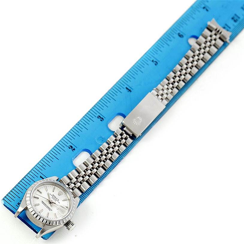 The Rolex Date 79240 Women's Stainless Steel Silver Dial 79240 Women's Stainless Steel Silver Dial model watch is shown from above, displaying the face, bracelet, and clasp alongside a ruler for scale.