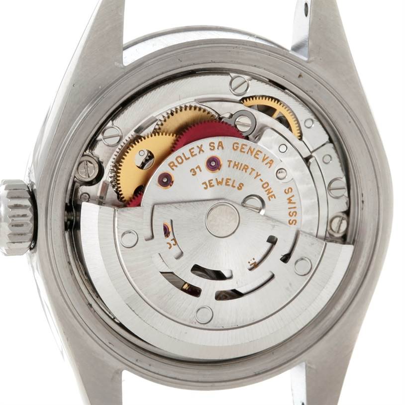 The image shows the movement of a Rolex Date 79190 Women's Stainless Steel Pink Dial 79190 Women's Stainless Steel Pink Dial model watch from a rear angle, highlighting its gears and mechanisms.