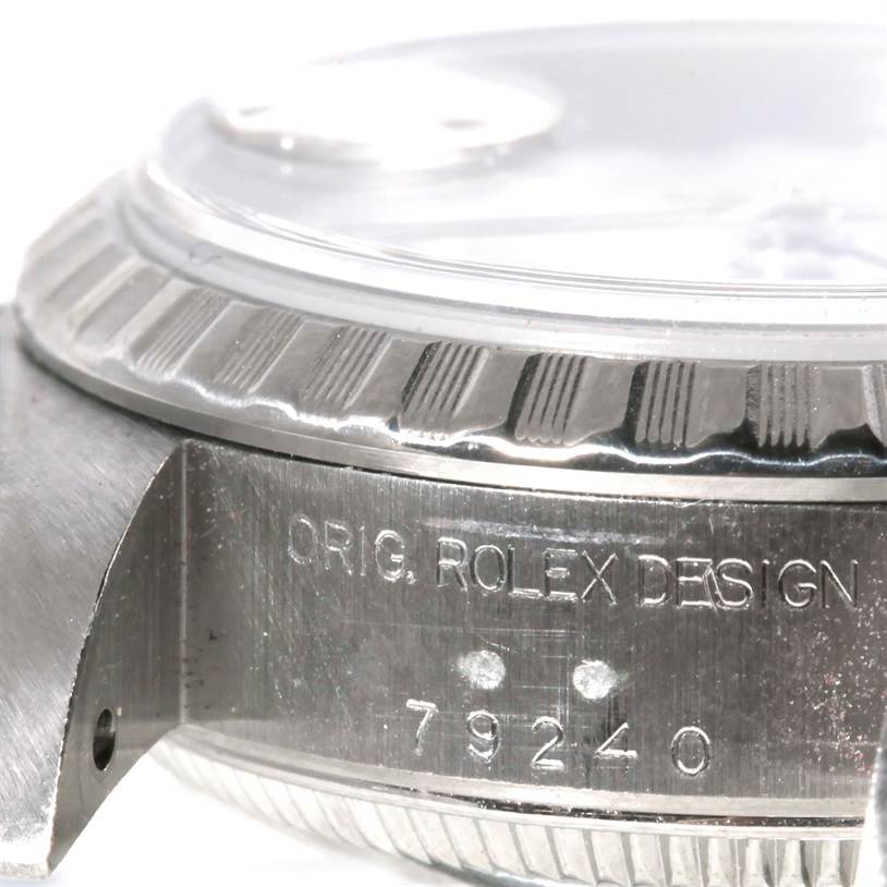 This close-up shot of the Rolex Date 79240 Women's Stainless Steel White Dial 79240 Women's Stainless Steel White Dial model shows the case side engraving with "ORIG. ROLEX DESIGN" and the reference number 79240.