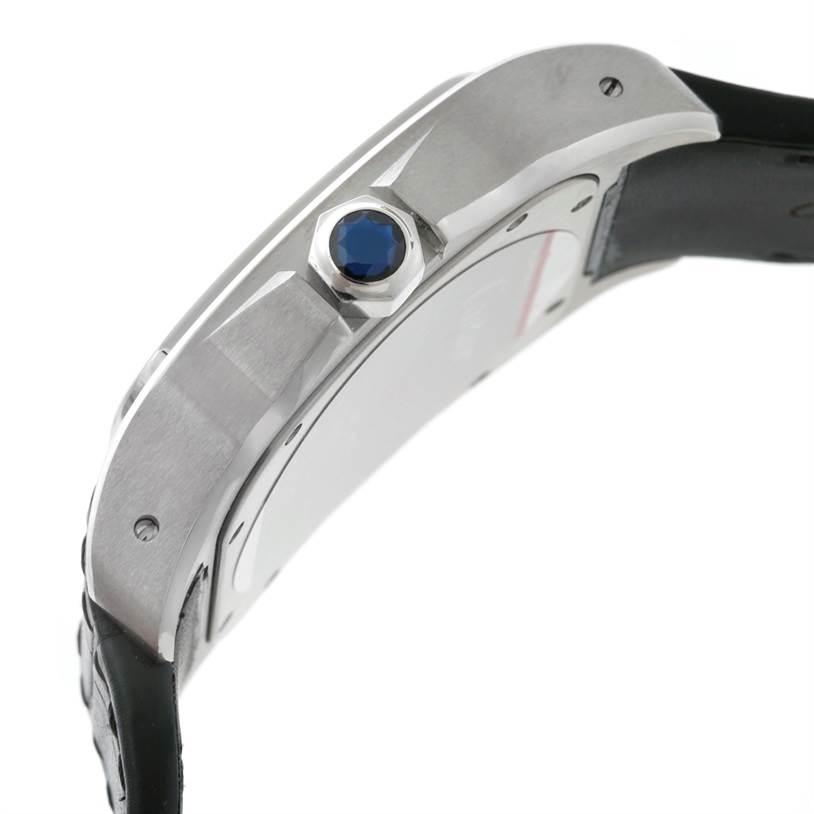 This image shows a side view of the Cartier Santos W20073X8 Men's Stainless Steel Silver Dial W20073X8 Men's Stainless Steel Silver Dial watch, highlighting the crown with a blue cabochon and part of the strap.