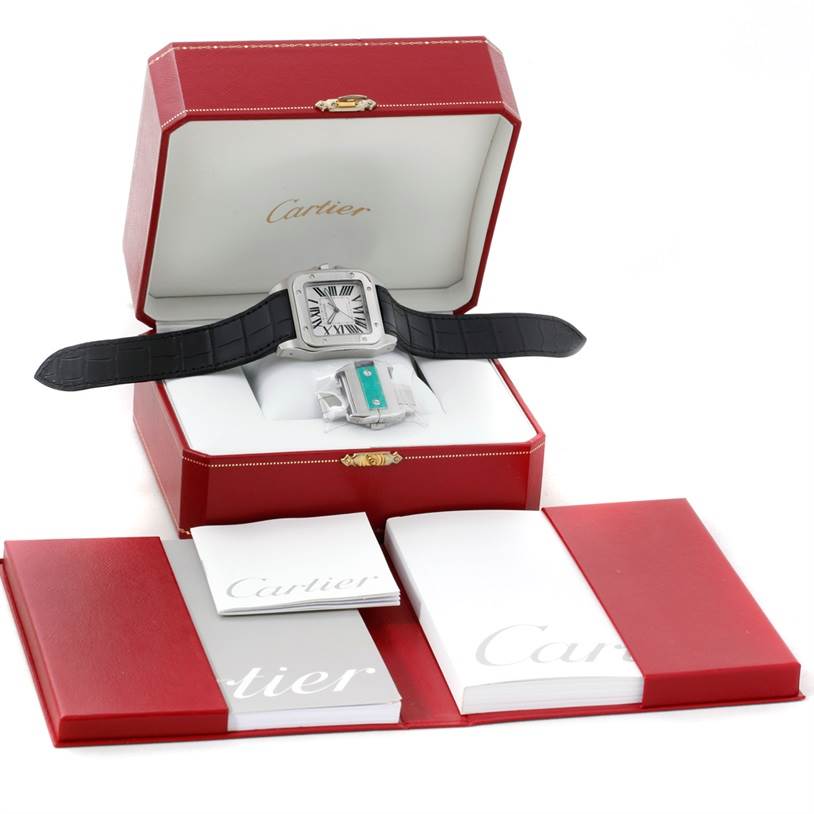 The image shows a Cartier Santos W20073X8 Men's Stainless Steel Silver Dial W20073X8 Men's Stainless Steel Silver Dial watch with a black strap, presented in an open red Cartier box with accompanying booklets.