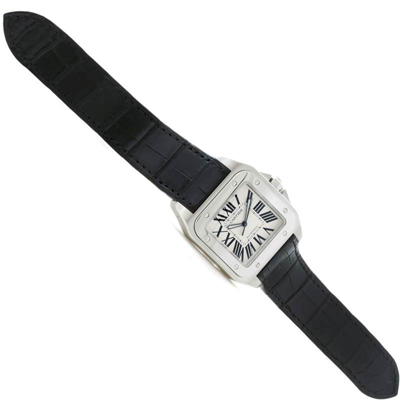 The Cartier Santos W20073X8 Men's Stainless Steel Silver Dial W20073X8 Men's Stainless Steel Silver Dial watch is shown from a flat, top-down angle, displaying the face, case, bezel, and black leather strap.