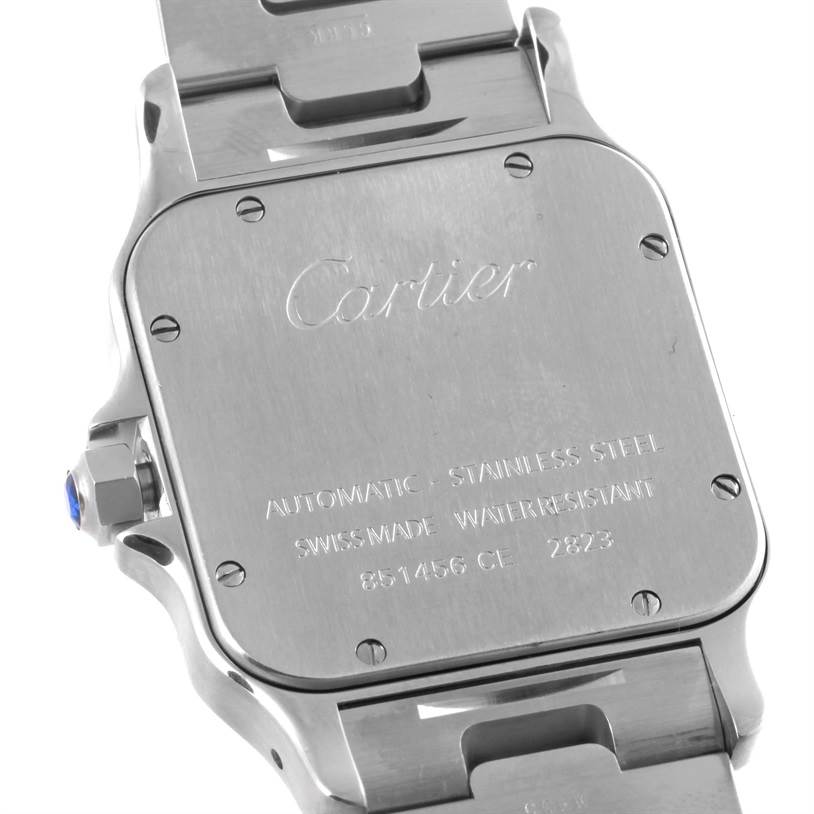 The image shows the back casing of a Cartier Santos W20098D6 Men
s Stainless Steel Silver Dial W20098D6 Men
s Stainless Steel Silver Dial watch from an oblique angle, displaying engravings and a portion of the metal strap.