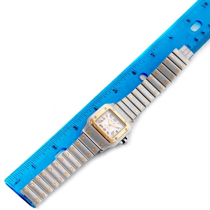 The image shows the Cartier Santos W20058C4 Men's Stainless Steel Silver Dial W20058C4 Men's Stainless Steel Silver Dial watch from a top-down angle with a blue ruler for scale.