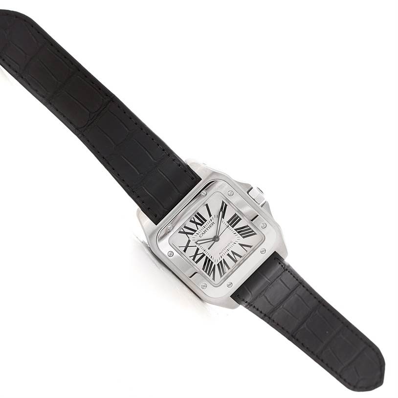 The Cartier Santos W20073X8 Men's Stainless Steel Silver Dial W20073X8 Men's Stainless Steel Silver Dial watch is shown at a slight angle, displaying its square face, black leather strap, and stainless steel casing.