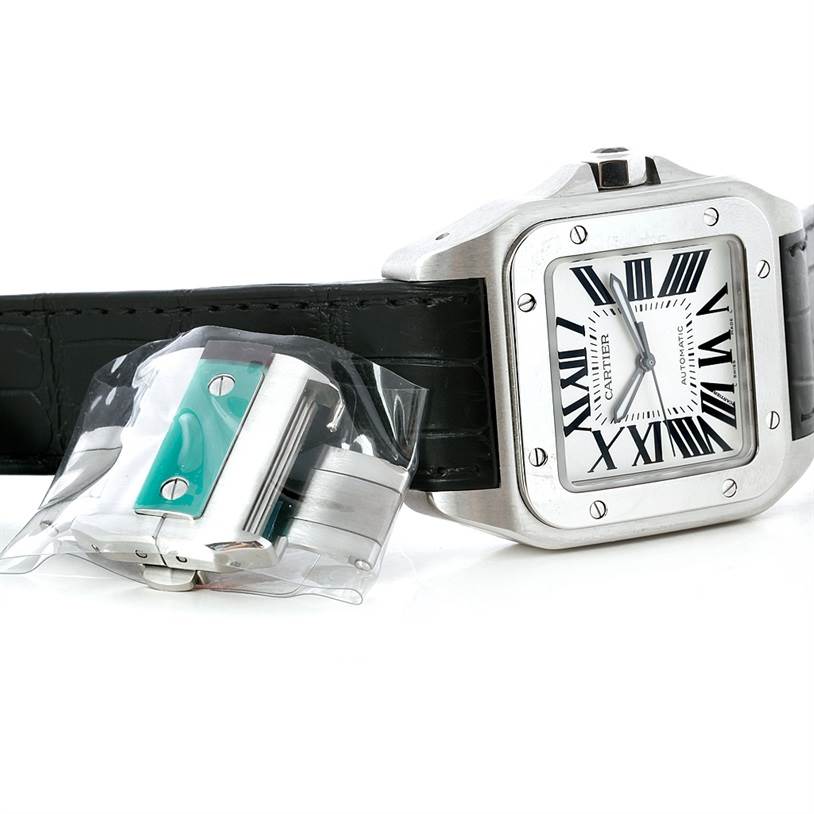 The image shows the Cartier Santos W20073X8 Men's Stainless Steel Silver Dial W20073X8 Men's Stainless Steel Silver Dial watch face, case, and leather strap along with an accessory wrapped in plastic.