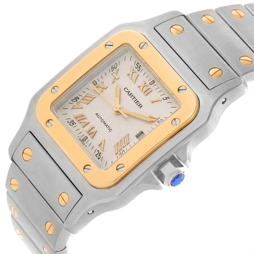 This image shows a close-up angled view of the Santos model by Cartier, highlighting the dial, bezel, crown, and metal bracelet with screws.