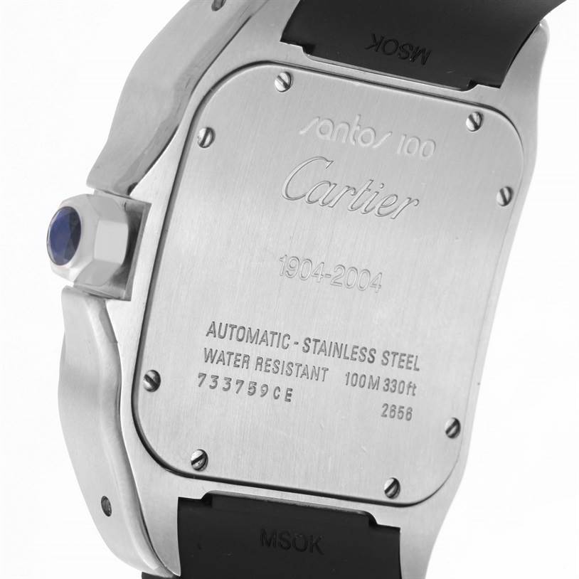 The image shows the back case of a Cartier Santos W20073X8 Men's Stainless Steel Silver Dial W20073X8 Men's Stainless Steel Silver Dial 100 watch, displaying engravings and a blue cabochon on the crown.