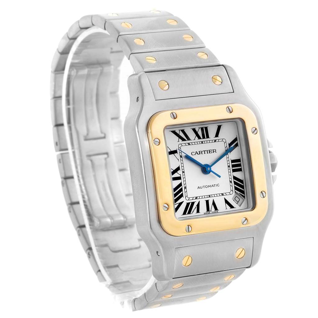 The image shows a Santos de Cartier watch from a front-left angle, highlighting its square face, metal bracelet, and two-tone bezel.