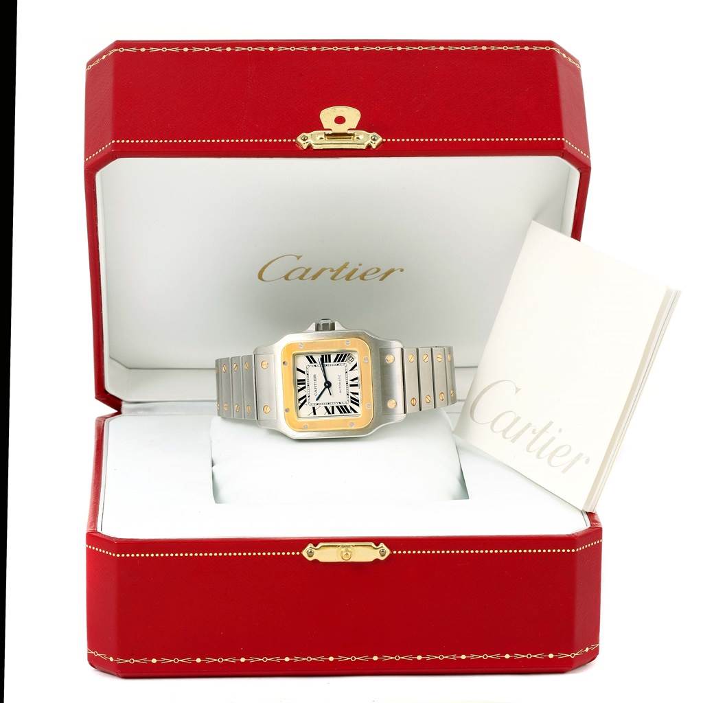 The image shows a Santos model by Cartier watch, displayed in an open red Cartier box with a booklet beside it.