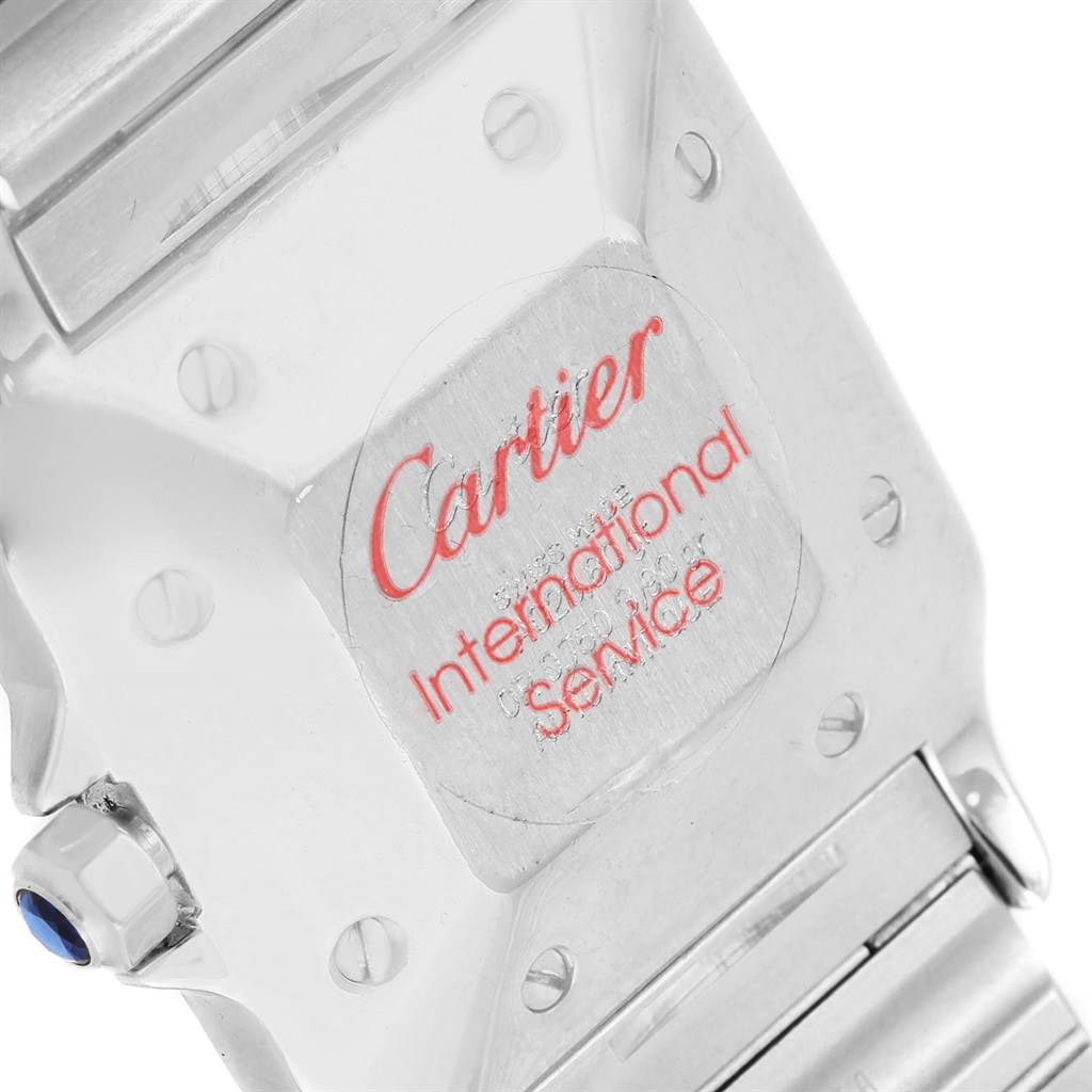 The image shows the back case and a part of the bracelet of a Cartier Santos W20058C4 Men
s Stainless Steel Silver Dial W20058C4 Men
s Stainless Steel Silver Dial watch with a Cartier International Service sticker.