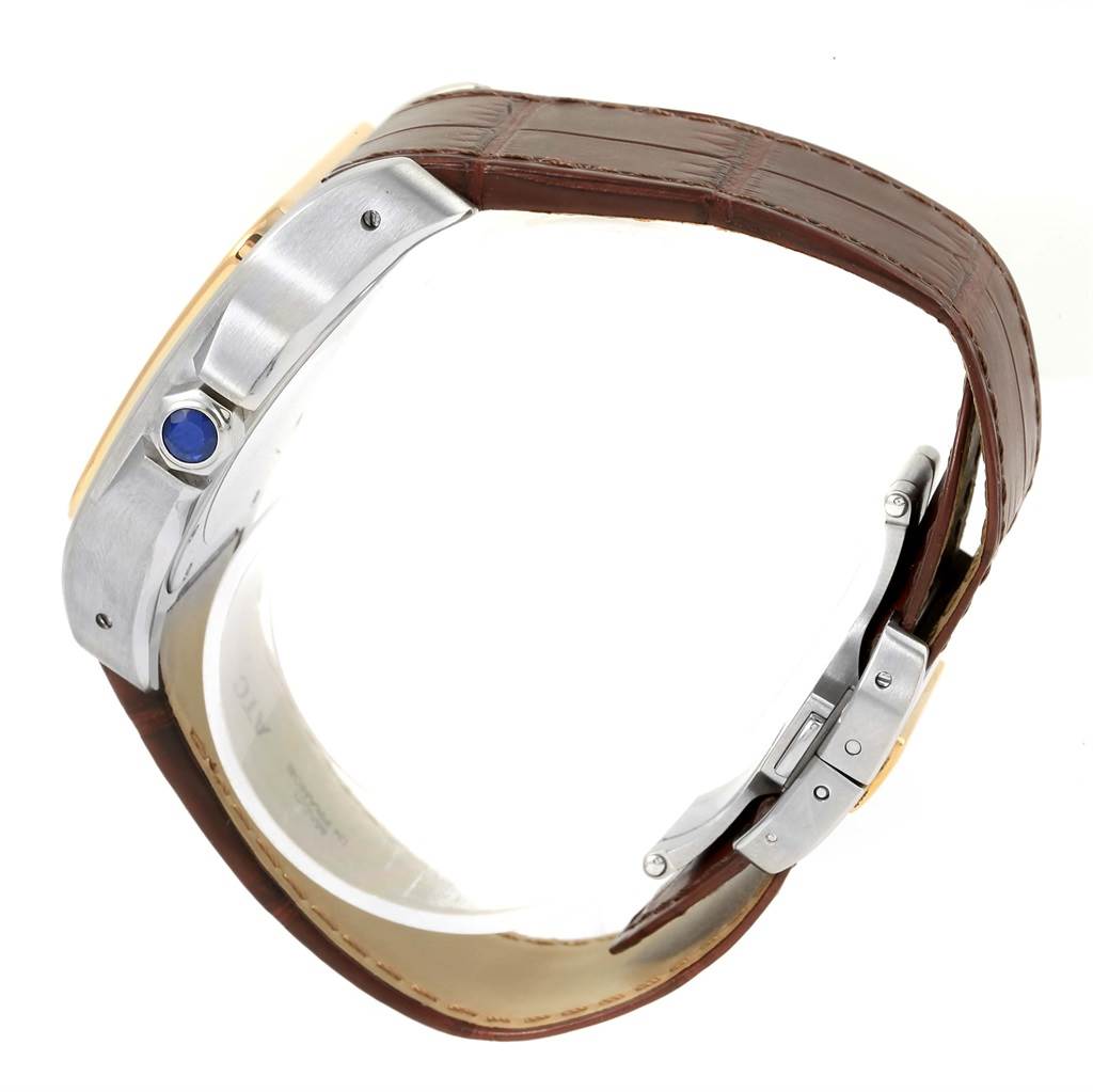 The image shows a side profile of the Santos model by Cartier, highlighting the case with a blue cabochon crown and brown leather strap with a clasp.