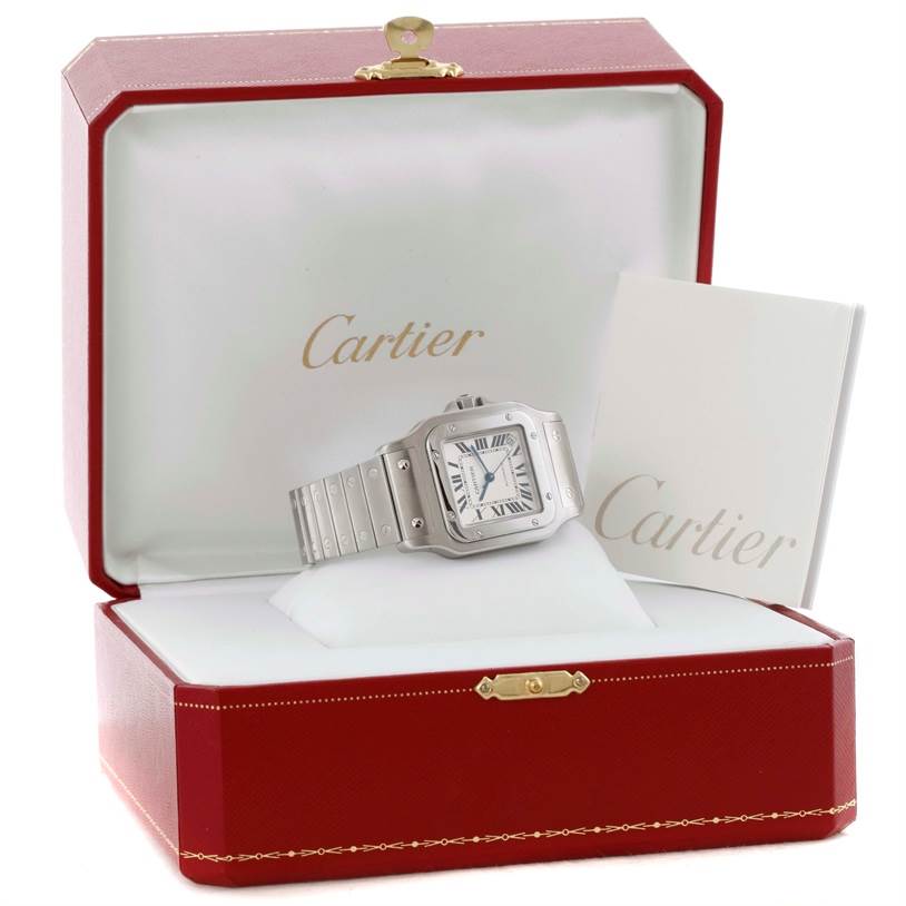 The Cartier Santos W20098D6 Men's Stainless Steel Silver Dial W20098D6 Men's Stainless Steel Silver Dial watch is shown from a front angle in an open Cartier watch box with a booklet.