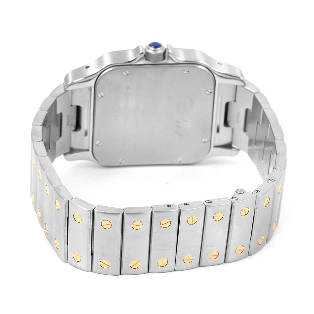 The image shows the back case and metal bracelet with gold screws of a Santos model by Cartier from an angled rear view.