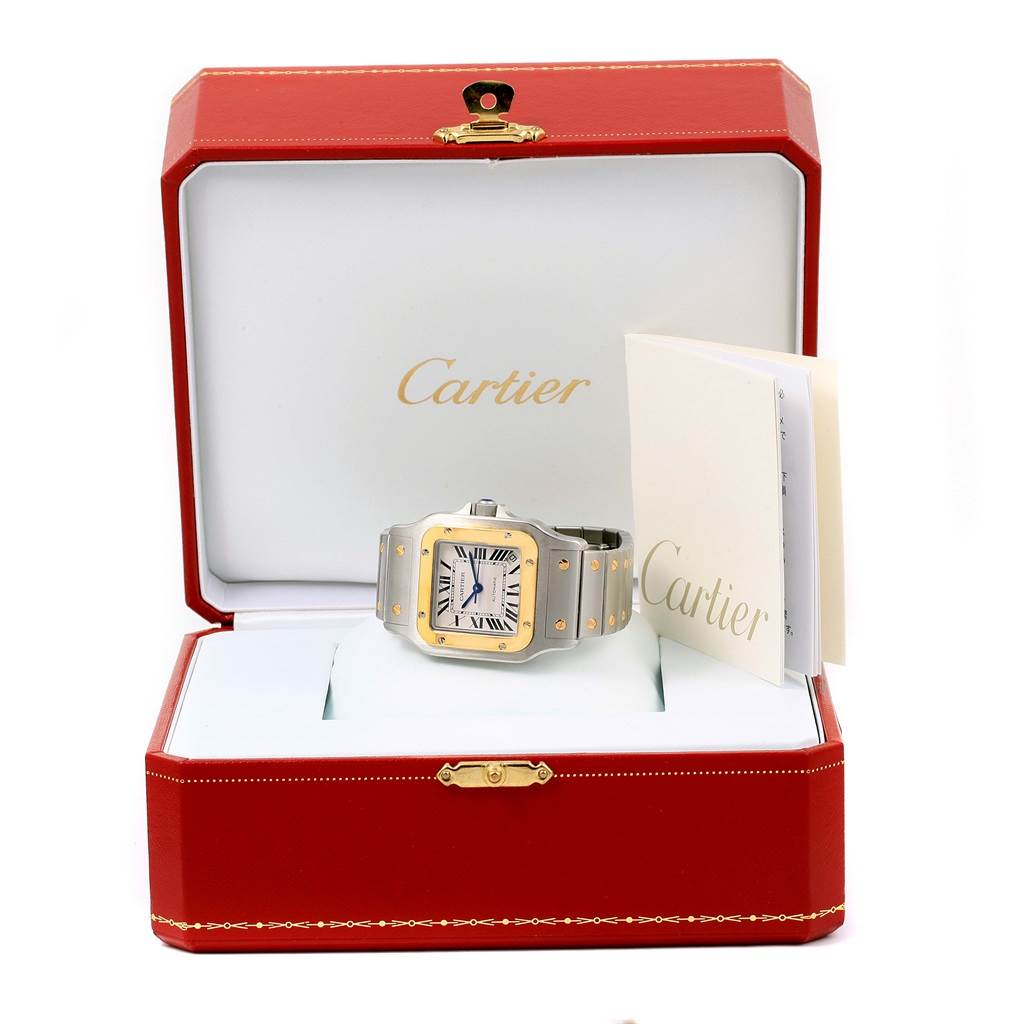 The Cartier Santos W20099C4 Men
s Stainless Steel Silver Dial W20099C4 Men
s Stainless Steel Silver Dial watch is displayed at an elevated angle inside its open red case, alongside documentation.
