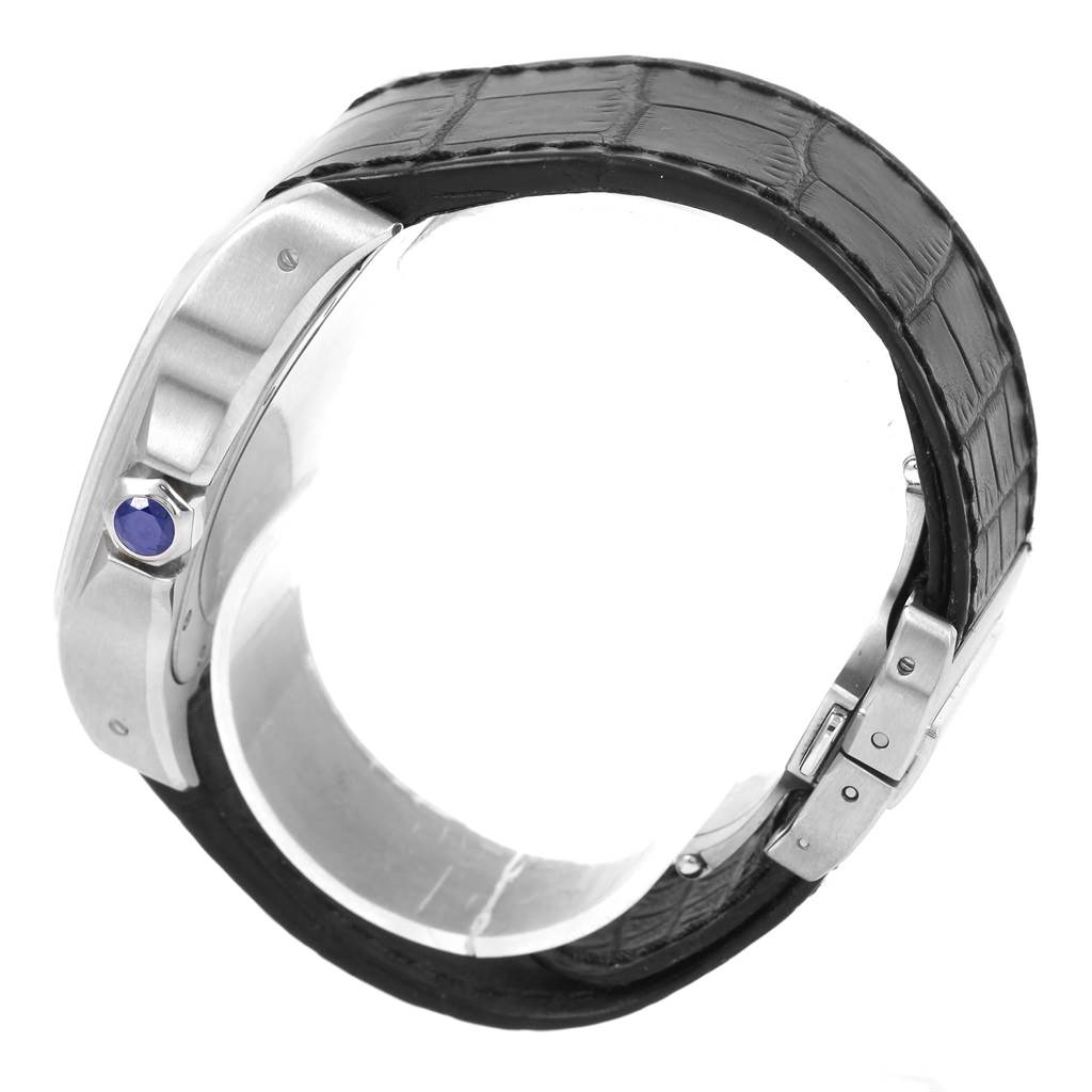 The image shows a side view of a Cartier Santos W20073X8 Men
s Stainless Steel Silver Dial W20073X8 Men
s Stainless Steel Silver Dial watch, highlighting its crown with a blue cabochon and black leather strap.