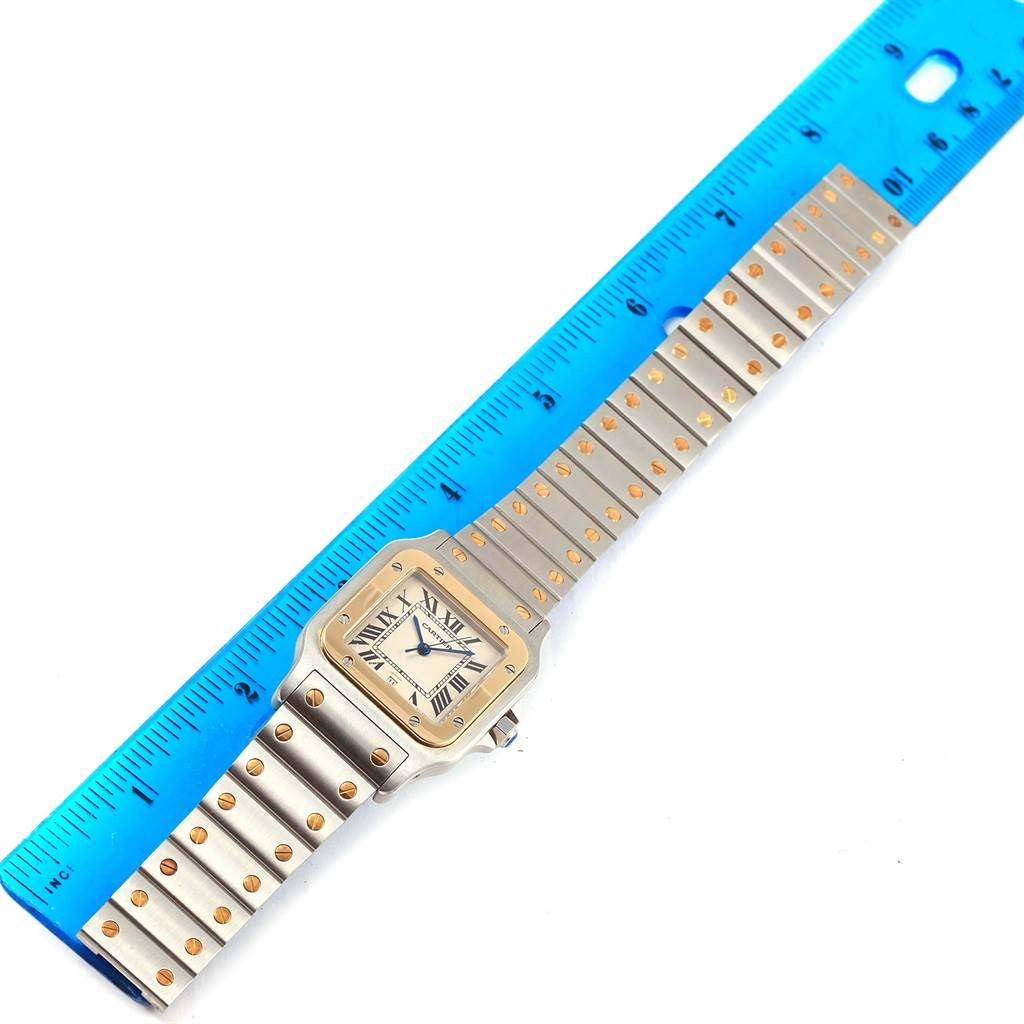 The image shows a Cartier Santos 1566 Stainless Steel Silver Dial 1566 Stainless Steel Silver Dial watch laid flat with a blue ruler beside it for scale, displaying the face and bracelet.