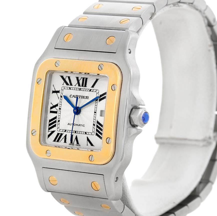 This image shows the Cartier Santos W20058C4 Stainless Steel Silver Dial W20058C4 Stainless Steel Silver Dial watch at an angle highlighting the face, bezel, crown, and part of the bracelet.