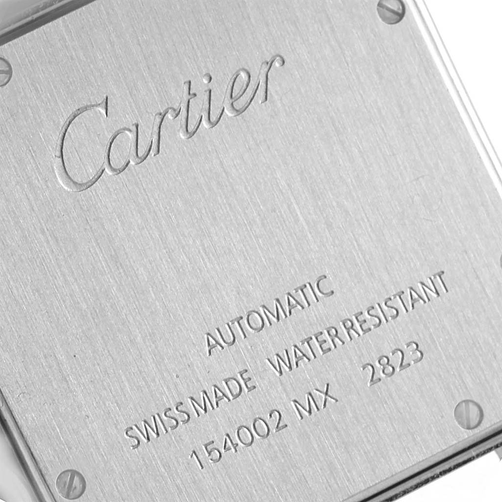 The image shows the back case of a Santos model watch by Cartier, displaying engravings and screws.