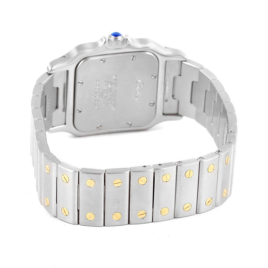The image shows the back and bracelet of the Santos model by Cartier, highlighting the clasp and stainless steel band with gold screws.