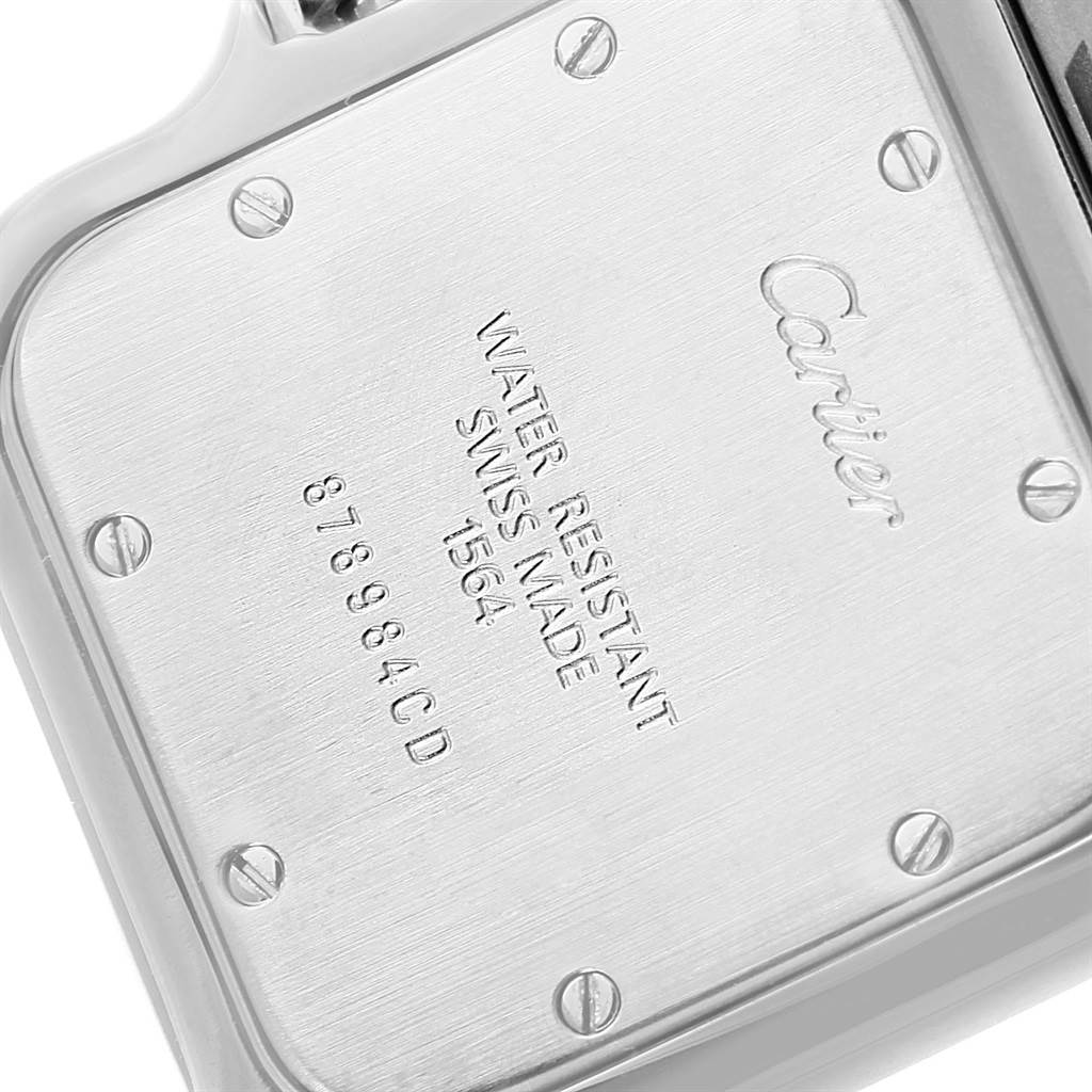 The image shows the back case of a Santos model by Cartier, highlighting the screws and engravings.