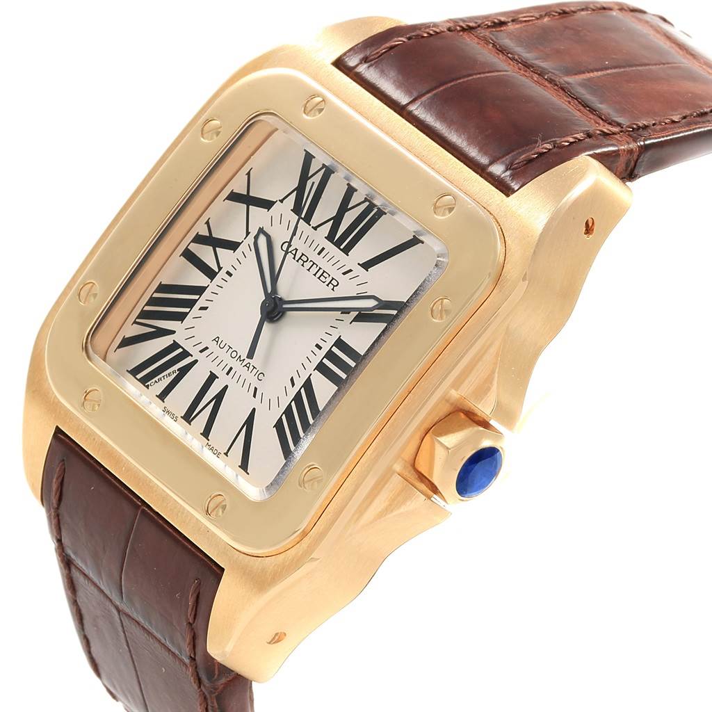 The Cartier Santos W20071Y1 Men's Yellow Gold Silver Dial W20071Y1 Men's Yellow Gold Silver Dial watch is shown from a slightly angled perspective, highlighting the dial, bezel, and leather strap.