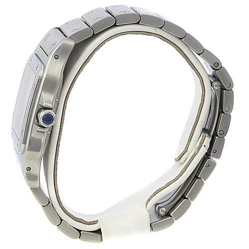 The image shows a side view of a Santos watch by Cartier, highlighting its metal bracelet and blue sapphire crown.