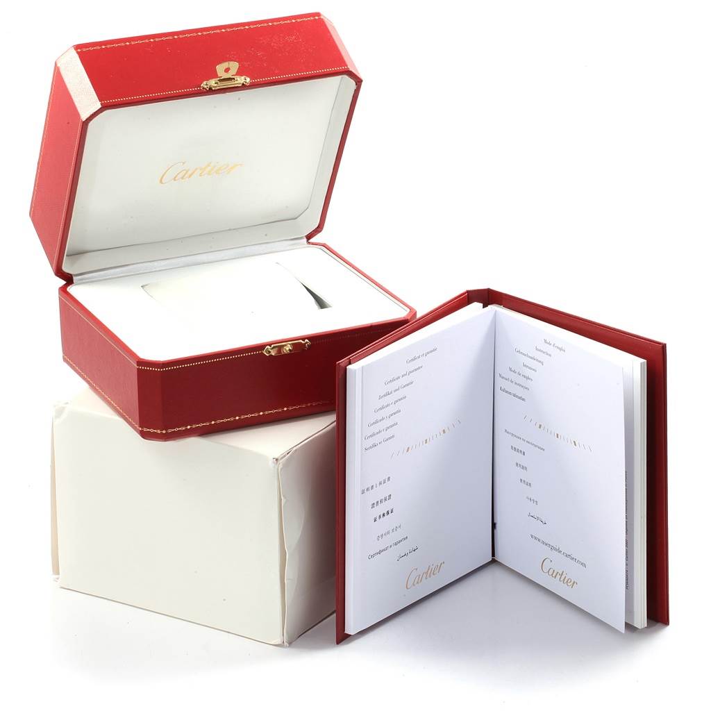 The image shows a Cartier Santos W20073X8 Men's Stainless Steel Silver Dial W20073X8 Men's Stainless Steel Silver Dial watch box and an open booklet with the Cartier logo.