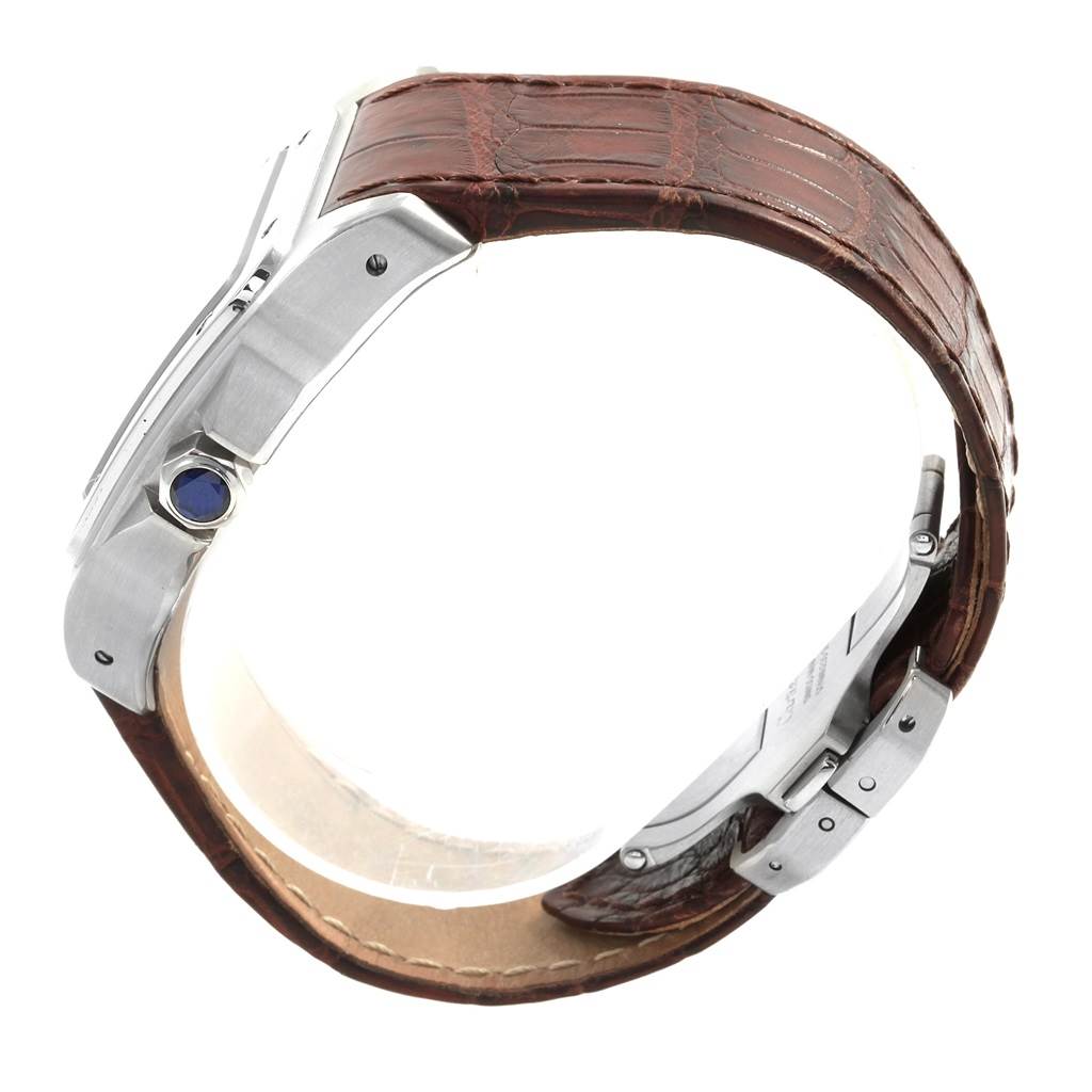 This image shows a Cartier Santos W20073X8 Men's Stainless Steel Silver Dial W20073X8 Men's Stainless Steel Silver Dial watch from a side angle, highlighting its brown leather strap and metallic casing with a blue crown.