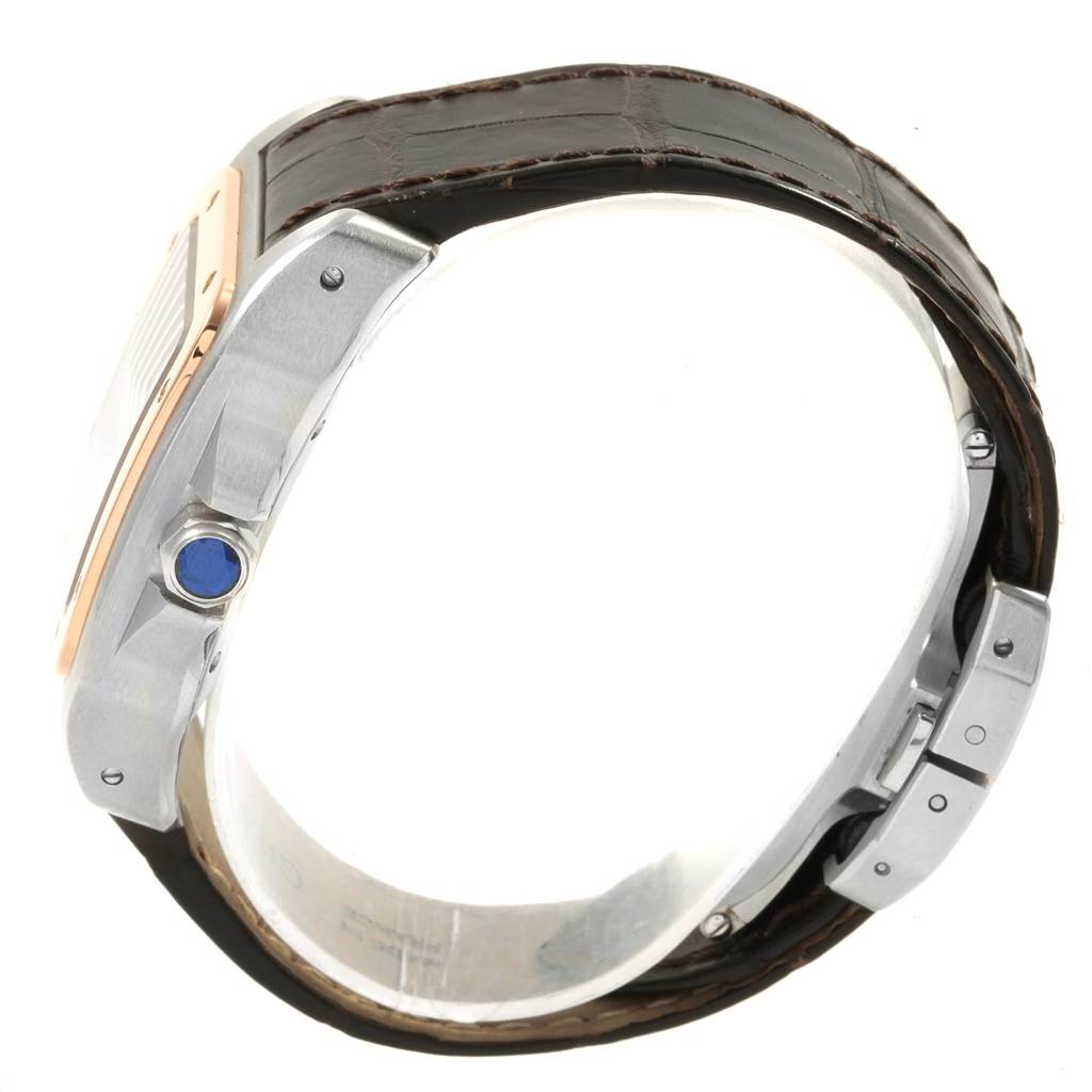 The image shows a side view of a Cartier Santos W20107X7 Men
s Stainless Steel Silver Dial W20107X7 Men
s Stainless Steel Silver Dial watch, highlighting its crown, bezel, and leather strap.
