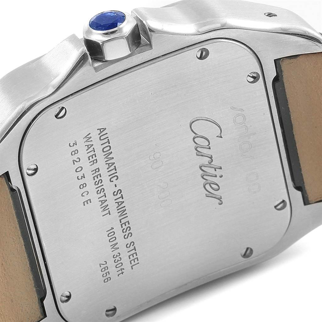 The image shows the stainless steel case back of a Cartier Santos W20073X8 Men's Stainless Steel Silver Dial W20073X8 Men's Stainless Steel Silver Dial watch, highlighting the inscriptions and the crown.