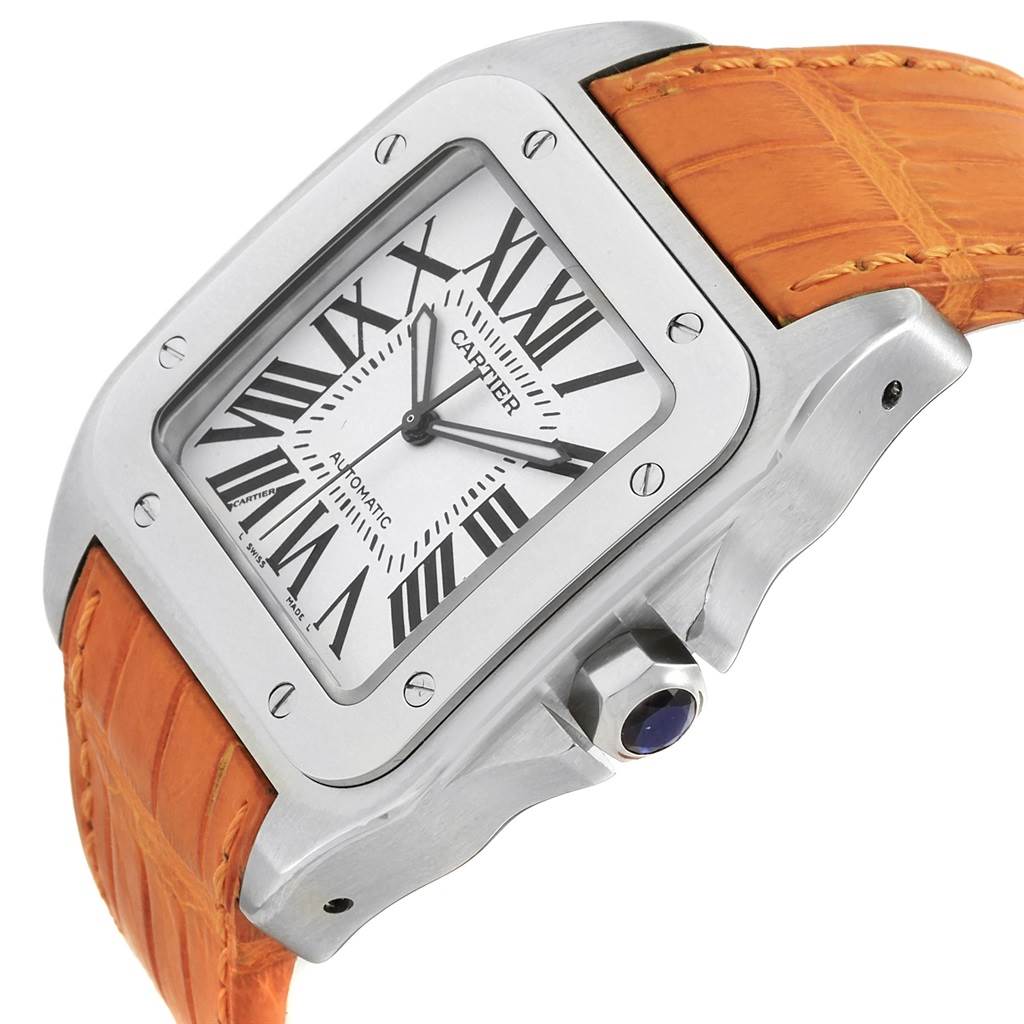 The image shows a close-up angle of a Cartier Santos W20073X8 Men's Stainless Steel Silver Dial W20073X8 Men's Stainless Steel Silver Dial watch, highlighting its face, bezel, crown, and orange leather strap.