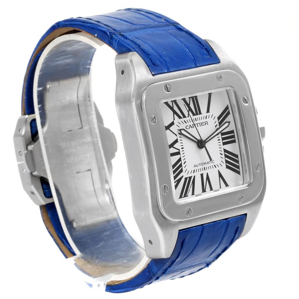 The image shows a Cartier Santos W20073X8 Men
s Stainless Steel Silver Dial W20073X8 Men
s Stainless Steel Silver Dial watch at an angled side view, displaying its square face with Roman numerals and a blue leather strap.