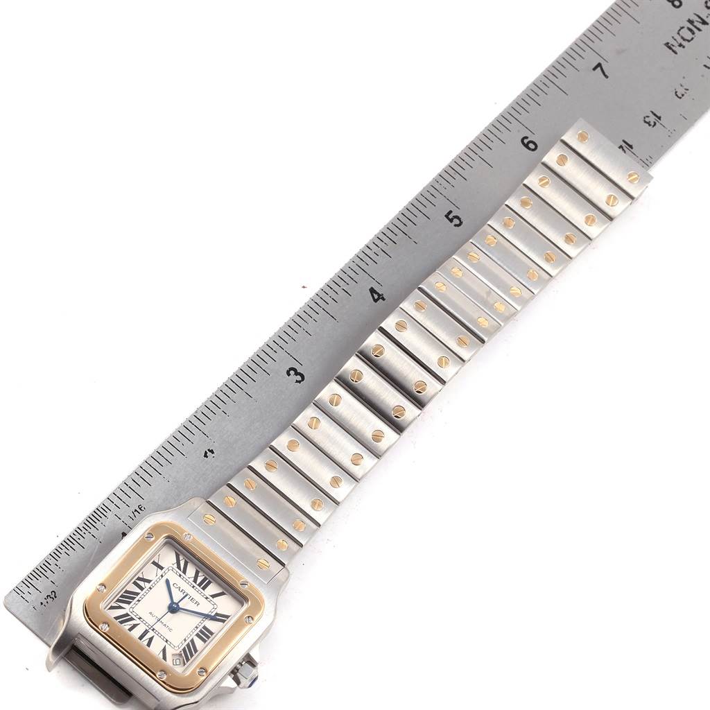 The image shows a Santos model watch by Cartier, laid flat with a ruler measuring its bracelet length.