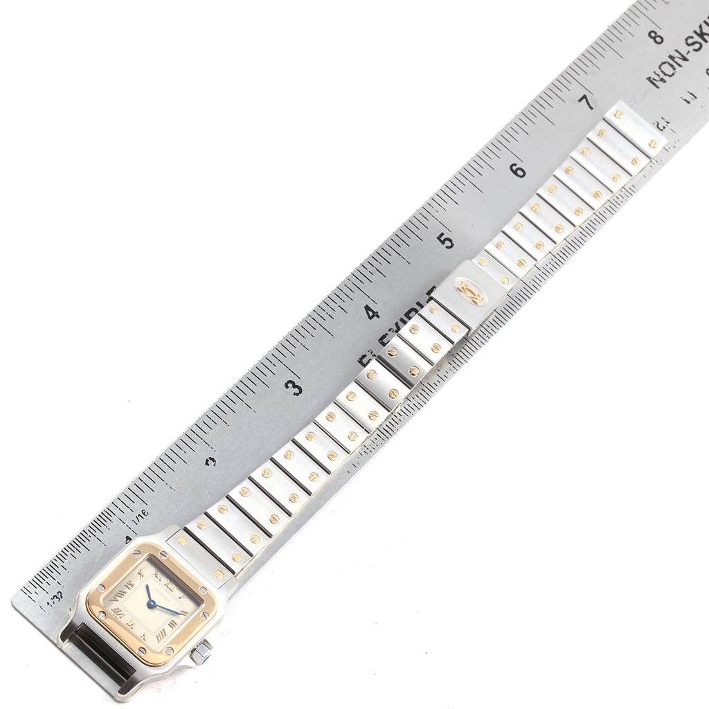 This image shows a Cartier Santos 1057930 Stainless Steel Grey Dial 1057930 Stainless Steel Grey Dial watch and its metal bracelet placed alongside a ruler for measurement.