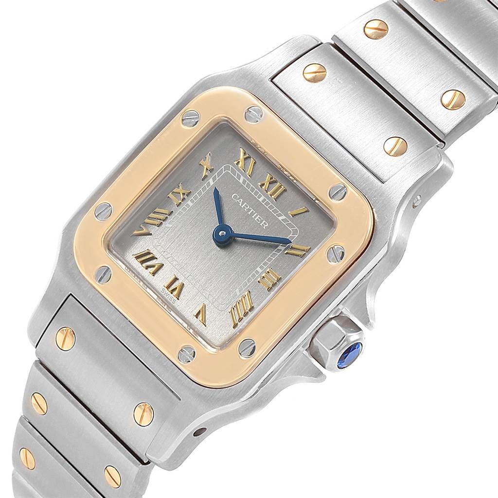 The image shows a close-up of the Cartier Santos 1057930 Stainless Steel Grey Dial 1057930 Stainless Steel Grey Dial watch, highlighting its square face, Roman numerals, and metal bracelet.